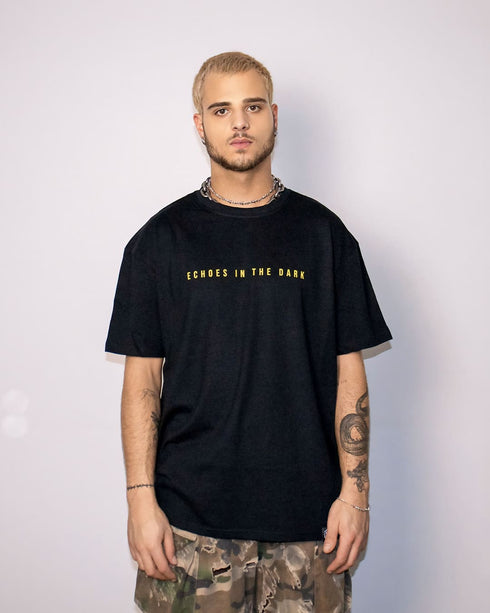 Echoes In The Dark Techno T-Shirt oversized in schwarz für Raver, Mann von vorne fotografiert