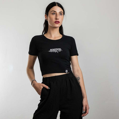 Rave Girl mit schwarzem Techno Crop Top mit "Decay" Motiv, fotografiert von vorne