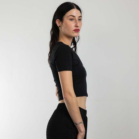 Rave Girl mit schwarzem Techno Crop Top mit "Decay" Motiv, fotografiert von der Seite