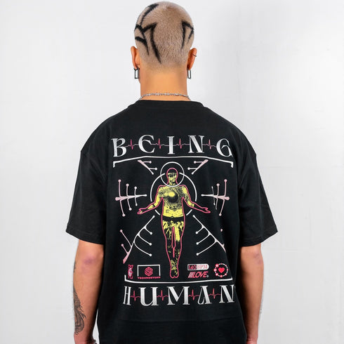 Raver mit schwarzem Being Human oversized T-Shirt in schwarz von Technostoff von hinten fotografiert