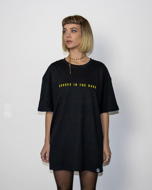Echoes In The Dark Techno T-Shirt oversized in schwarz für Raver, Frau von vorne fotografiert