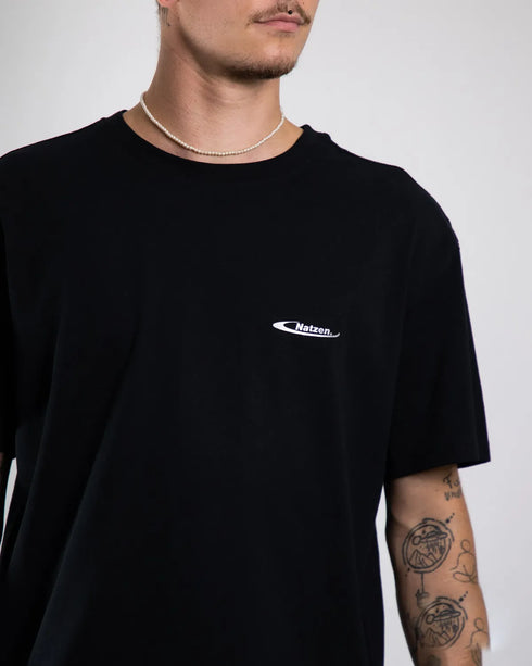 "Natzen" silverreflex oversized T-Shirt für Raver in schwarz, von Technostoff Streetwear, getragen von einem Mann, fotografiert von vorne mit Fokuspunkt auf kleinem Brustlogo