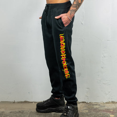 Raver trägt Technostoff Sweat Pants Jogger in schwarz mit rotem Technostoff Stripe Aufdruck