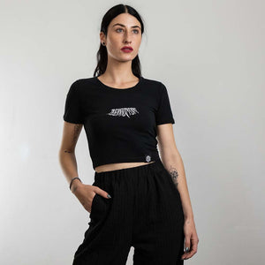 Vrouwelijke raver draagt zwart Technostoff Decay crop top, achteraanzicht