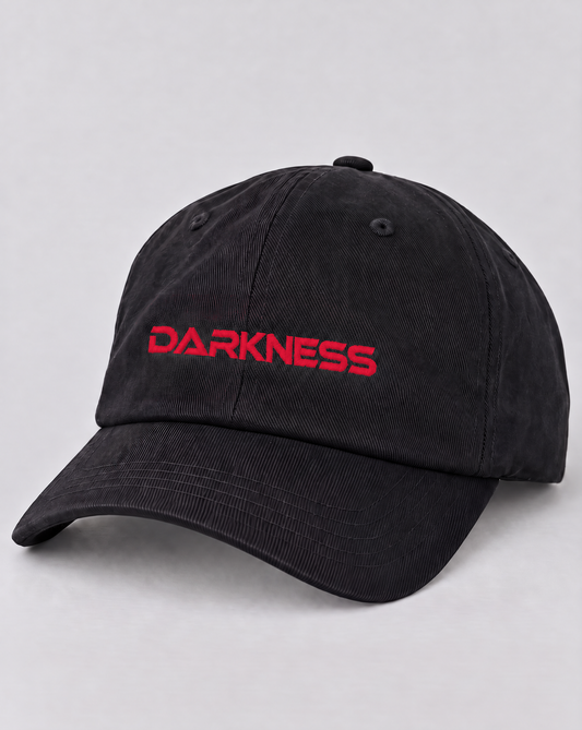 Technostoff DARKNESS Cap in Schwarz mit rotem 3D-Stick DARKNESS auf der Vorderseite, gebogener Schirm und Lüftungsösen, Produktansicht schräg von vorn auf hellgrauem Hintergrund
