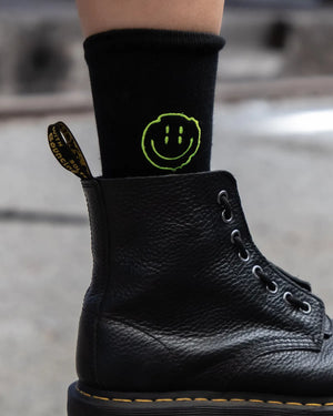 Raver traegt schwarze Technostoff Distorted Smile Socken, Nahaufnahme