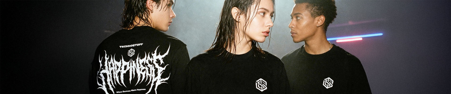 Drei junge Menschen tragen schwarze Techno Streetwear T-Shirts von Technostoff in einem clubähnlichen Setting.