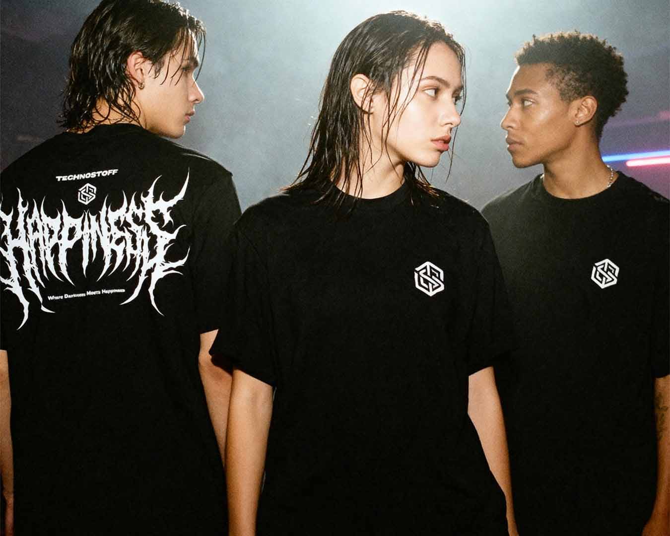 Drei junge Menschen tragen schwarze Techno Streetwear T-Shirts von Technostoff in einem clubähnlichen Setting.