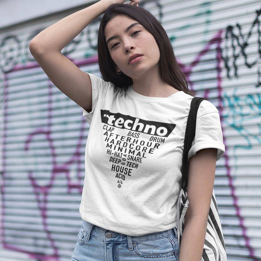Female raver wearing the white Technostoff Techno Triangle T-shirt with triangle word print in front of graffiti wall